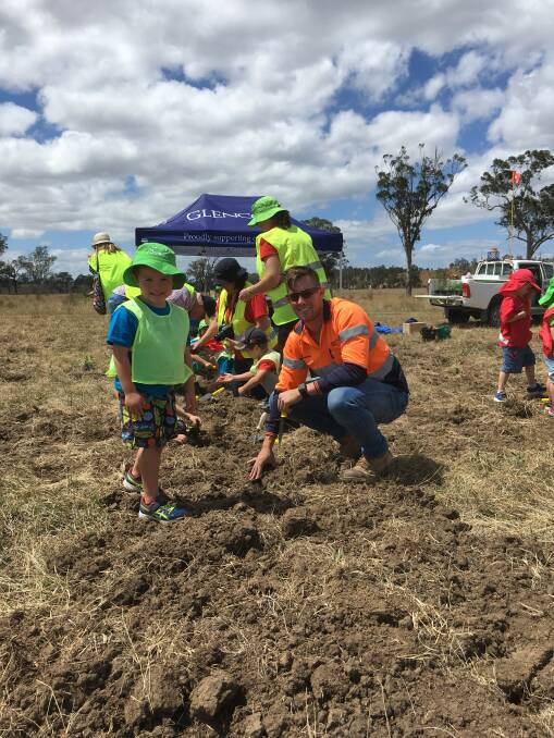 ALL HANDS ON DECK: Ravensworth’s Environment and Community officer Brenton Hubert helps the pre-schoolers plant the seedlings.