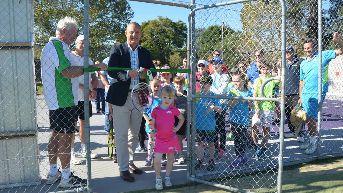 OPEN FOR BUSINESS: Upper Hunter MP Michael Johnsen, with the help of youngster Charlotte Stanford-Lucas, unveils the new Hotshots courts at the Howe Park Tennis Club on Saturday.
