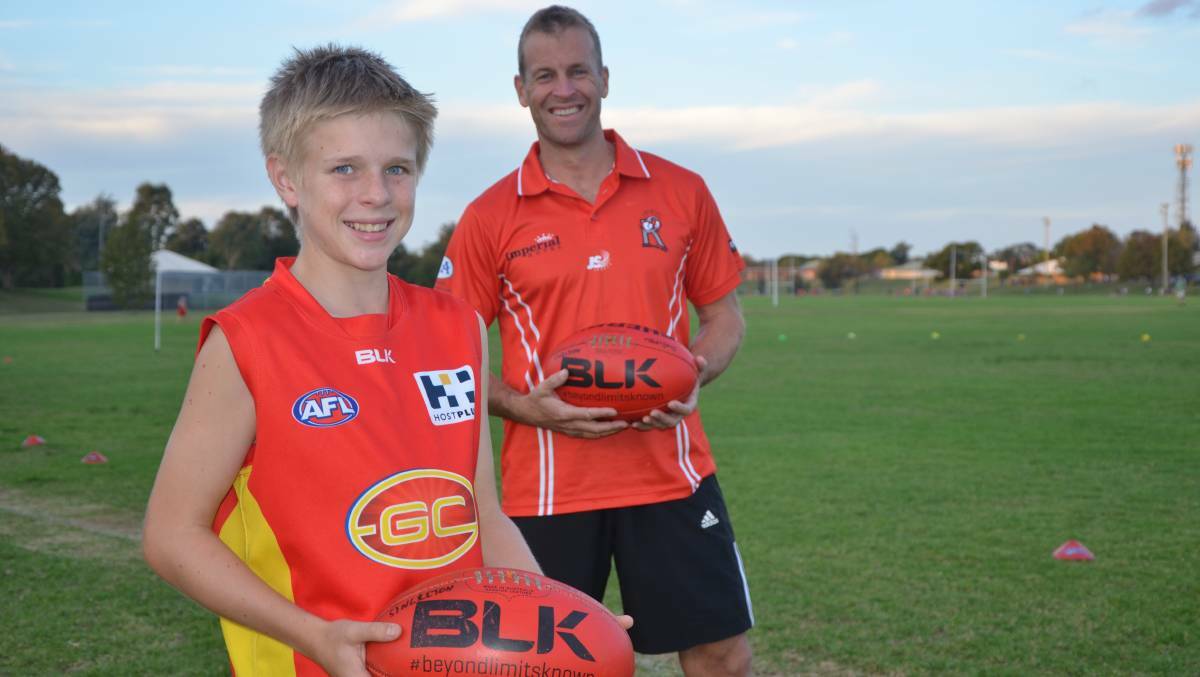 MAJOR HAUL: Singleton Roosters full forward Travis Bates, with son Jesse, kicked 17 goals in Saturday's victory.