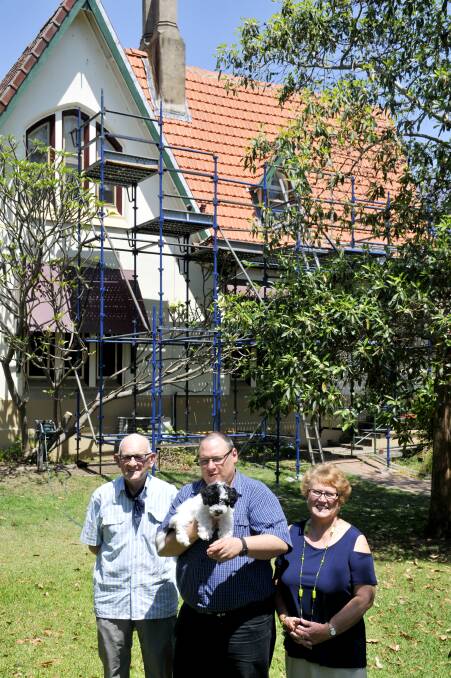 RESTORATION: Local Historian Roy Palmer, Arch Deacon Charlie Murry with puppy Max and Robyn Wylie from the Parish Council in front of the newly restored portion of the roof. 