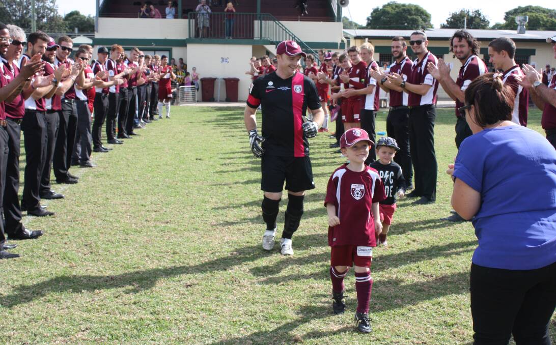200th GAME:  Ryan with his sons, Eli and Archie, coming through the guard of honour on Saturday, with wife Laura about to greet them as they emerge.