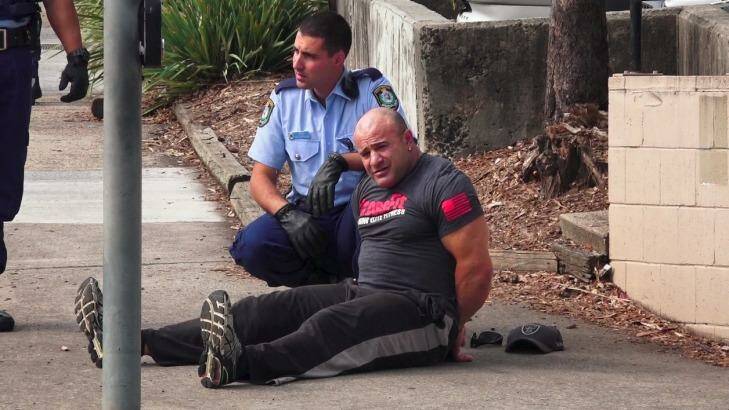 An unidentified man was handcuffed following the fatal shooting at Bankstown Central Shopping Centre, but was later released. Photo: Top Notch Video