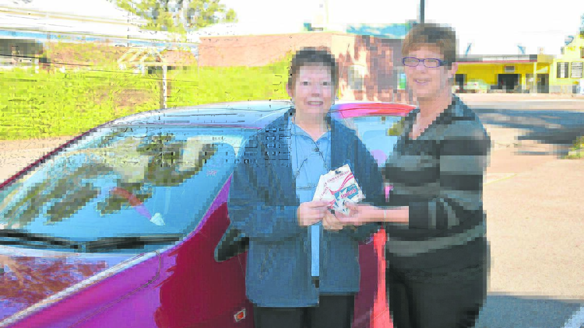 Daphne Maxwell being presented with her voucher from Singleton Argus manager Vicki Caelli.