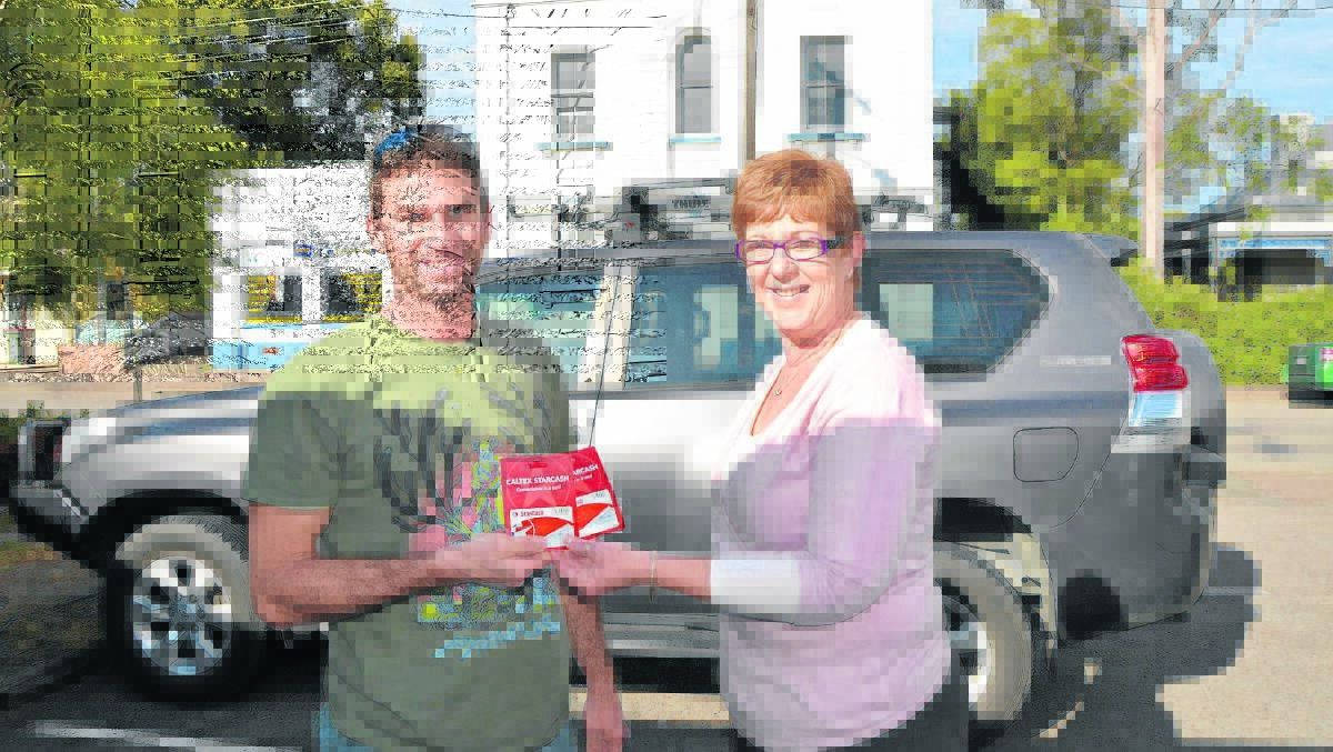 David Tattis third place winner being presented with his voucher from Singleton Argus manager Vicki Caelli.