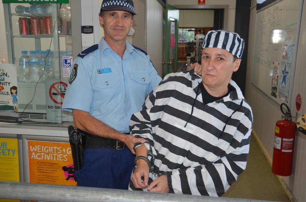 Police youth liaison officer constable Scott O'Riley handcuffs Singleton PCYC relieving manager Rebecca Loughton.