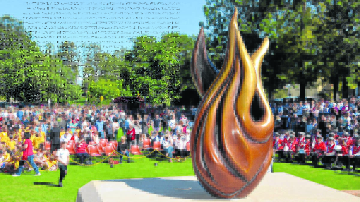 HONOURING: The crowds gather on Civic Green for Saturday’s Anzac Day service. In the foreground  is our newly-unveiled beautifully sculptured eternal flame.
