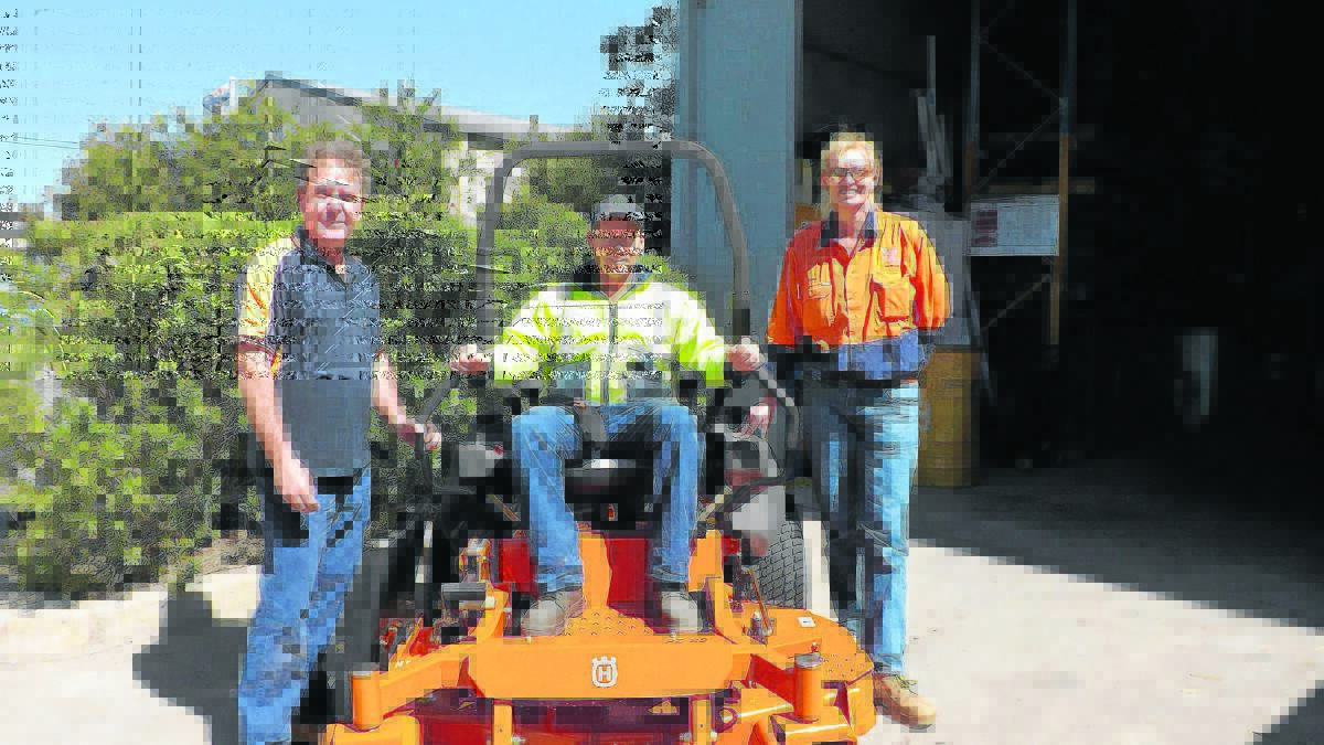 TAKING DELIVERY: D & L Chainsaws manager Kevin Penton, Matt Starr and Witmore’s workshop manager Donna Frankham.