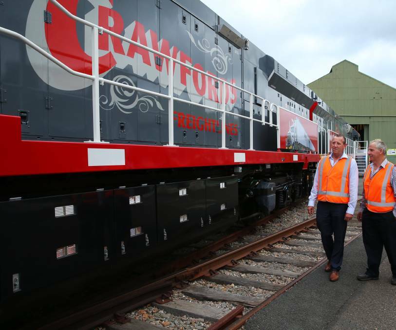 TRAINS SET: UGL's Rod Morrison and Crawfords Freightlines' Peter Crawford inspect two Newcastle-built locomotives at Broadmeadow. Picture: Max Mason-Hubers.