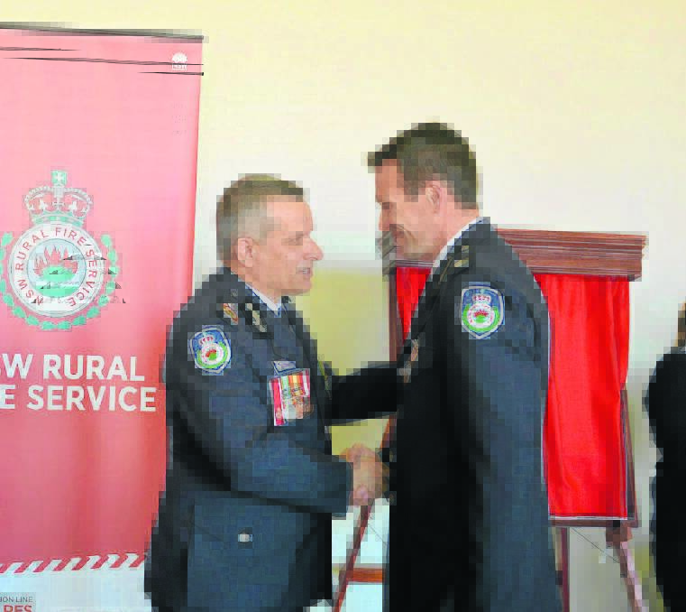 PICTURED RIGHT:  New South Wales RFS deputy commissioner Rob Rogers awards Martin Siemsen with a national award for 20 years service to the Rural Fire Service.