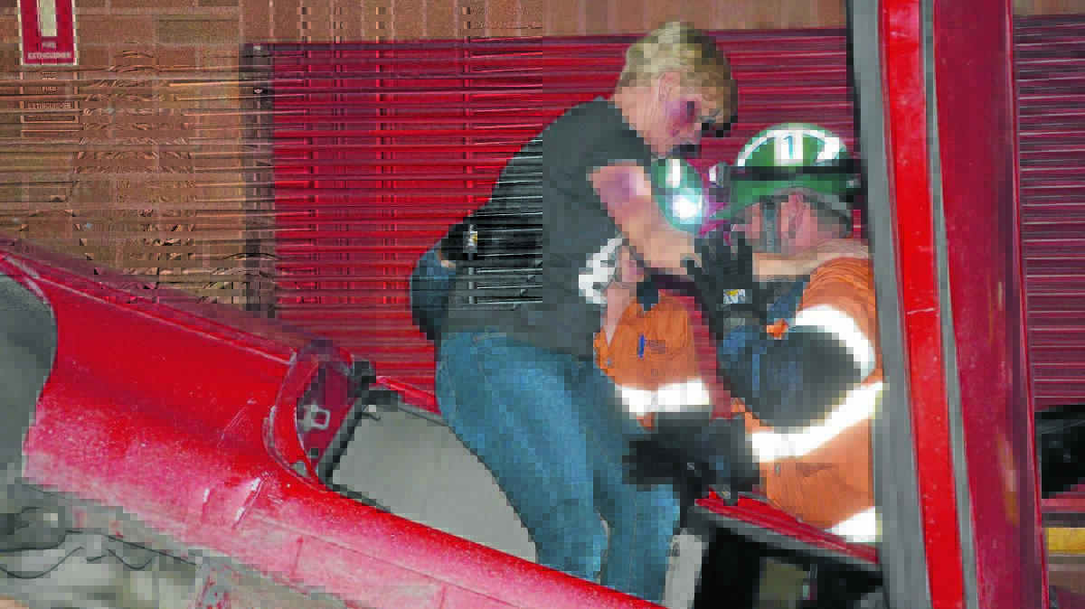 IN THE DARK: Liddell miners help 
a woman out of an over-turned 
vehicle, as part of the night time car crash scenario.  