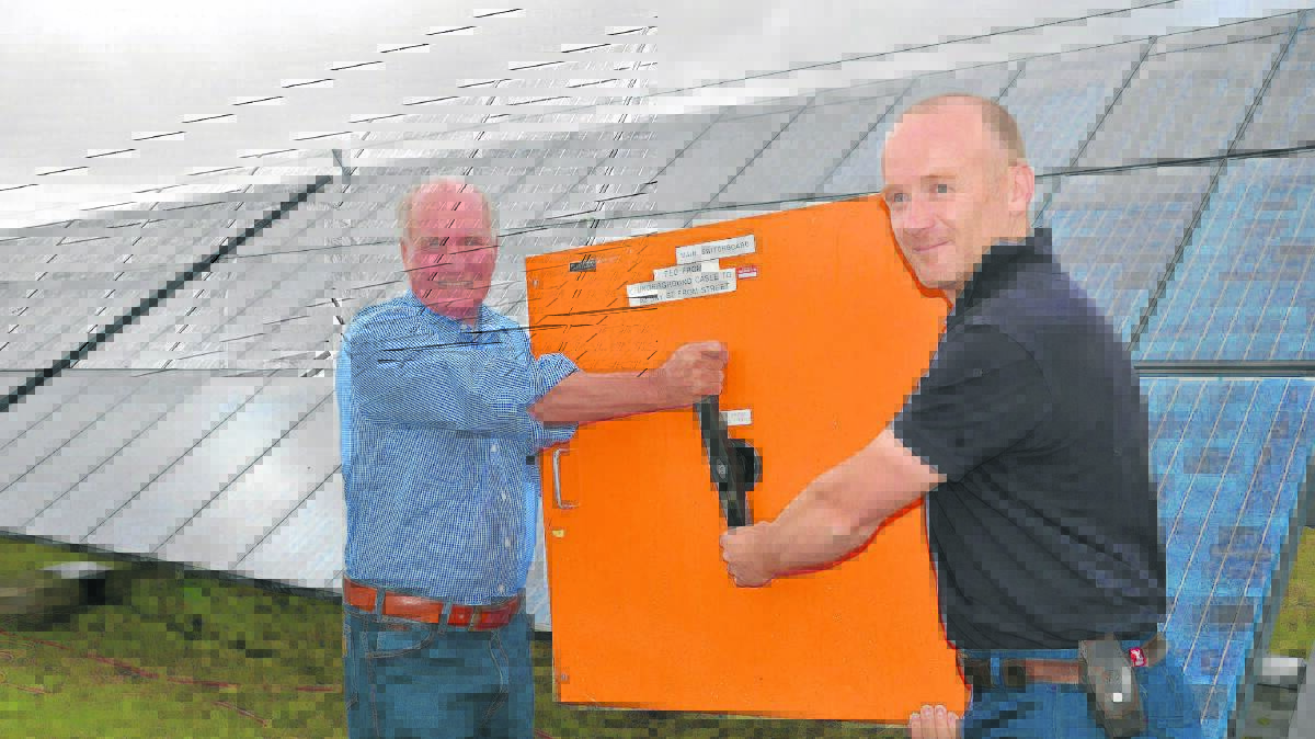 POWER RETURNS: Retired politician Tony Windsor helps Singleton Solar Farm owner Andrew Thaler switch the power back on. 
