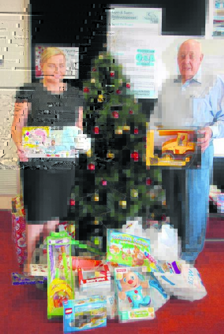 SWEET DEAL: Pay clerk Kirsty Oldham and Singleton mayor John Martin with some of the toys purchased with the proceeds of chocolate sales. 