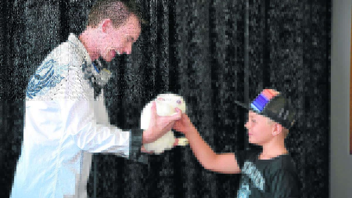 LUCKY ONE: OOSH care’s Jacob Merrick helps magician Joel Howlett during the magic show.