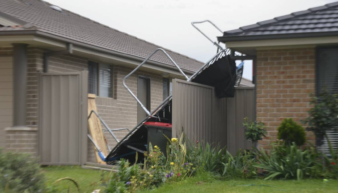 Trampoline rests on a fence after being blown into an adjoining property in today's winds 