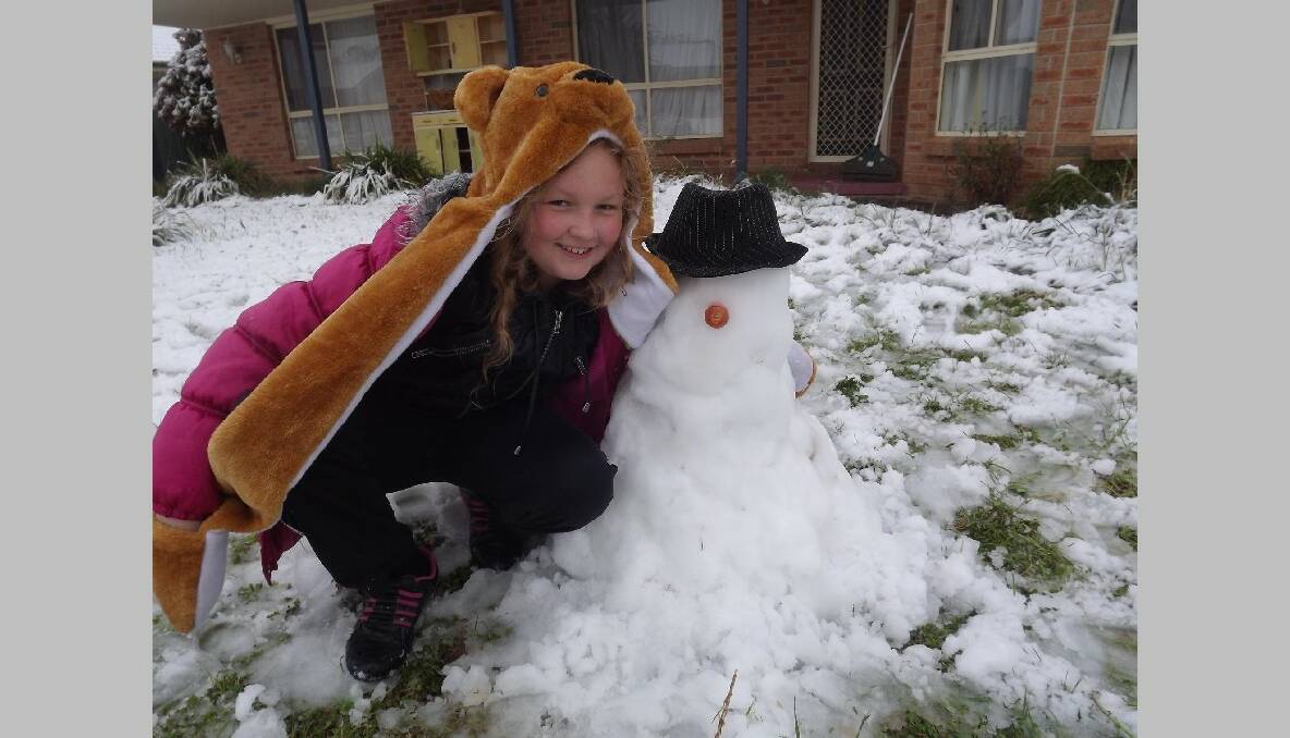 GOULBURN, NSW: "Kiera Cunningham and her Snowman Harry! This is the first time Kiera has ever seen snow. Kiera has saved two snow balls in the freezer for her Nanny and Poppy when they visit in 2 weeks. This is her first attempt at a snow man." Photo: Louise Edwards