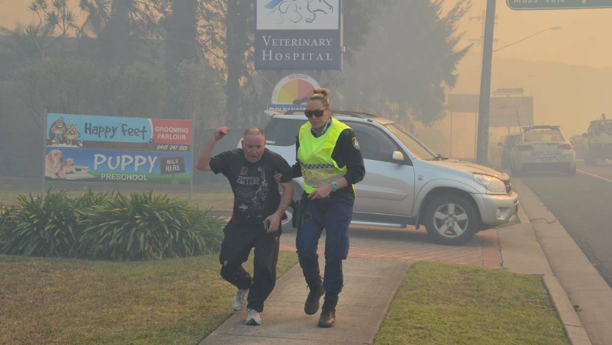A resident is evacuated from his Princes Highway home as fire bears down in Bomaderry. The August 2018 fire emergency got national attention because it flared up in winter. 