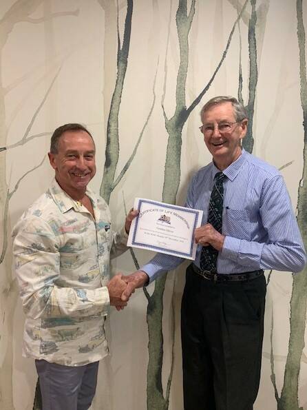 Club Singleton Chairman Kerry Hardy presenting Club Singleton Life Member Gordon Oliver with a certificate of life membership at the Club recently.