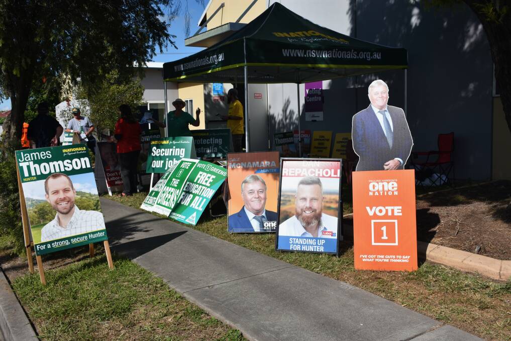 DEMOCRACY: The footpath outside the pre polling centre in Singleton is festooned with candidates corflutes as volunteers handout how-to-vote flyers. 