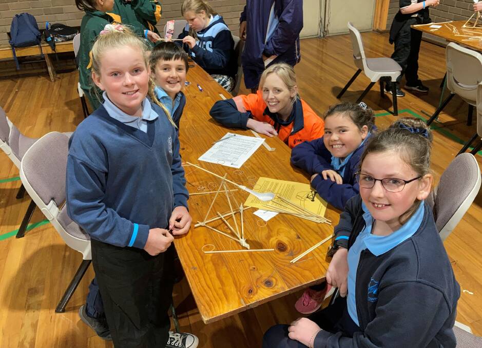  Yancoals Aleisha Tindall and students from Muswellbrook Public School with their miniature catapult under construction at the primary school Science and Engineering Discovery Day. Photo supplied.