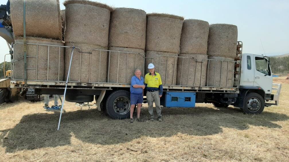 Doug Waddell and John Burton with some of the 350 round bales donated to Hunter farmers.
