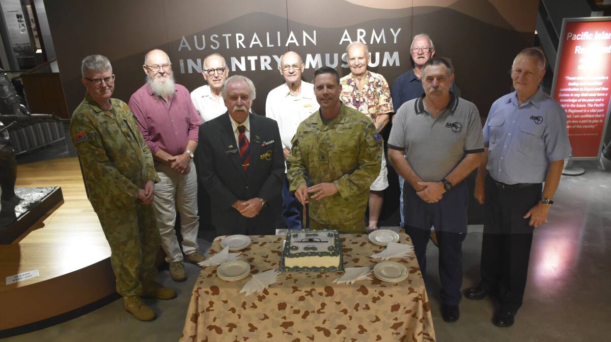 CELEBRATIONS: Volunteers and serving Army History Unit personnel cutting the Australian Army History Unit's 21st birthday cake.