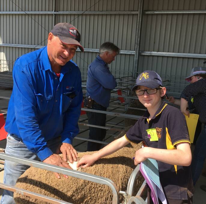 Merino sheep steward Warrick Nairne showing Merriwa Central student, Koda Cashen how to compare fleece quality at the junior judging workshops.