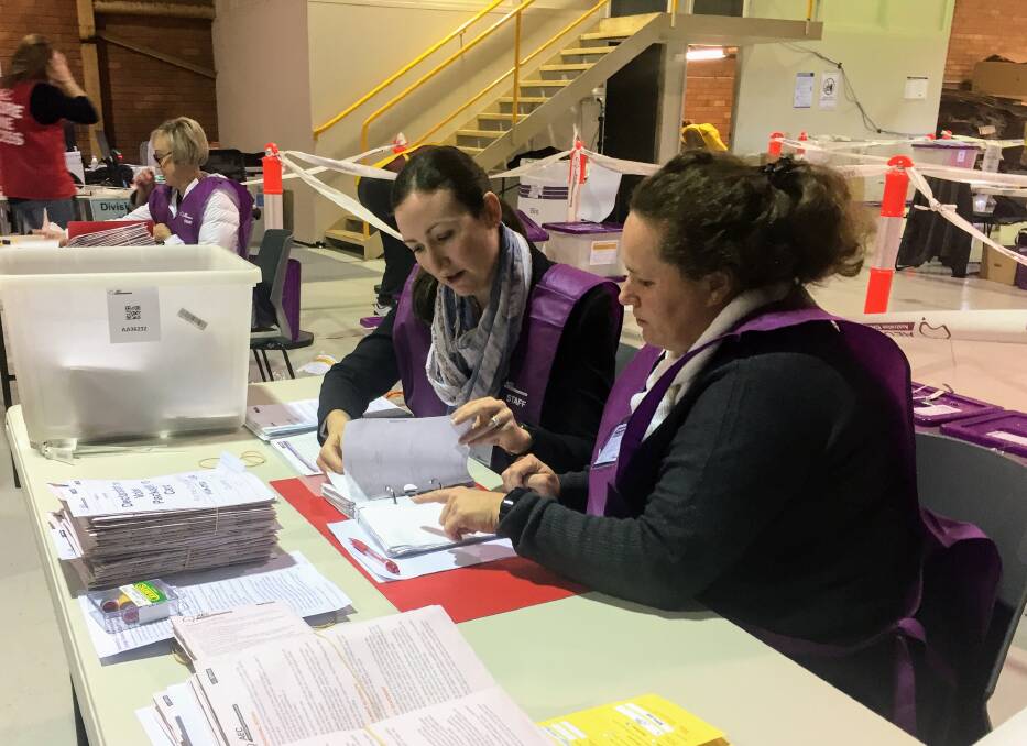 PAPER TRAIL: Australian Electoral Commission staff at the East Maitland counting centre sort through declaration votes on Sunday. Picture: Michael Parris