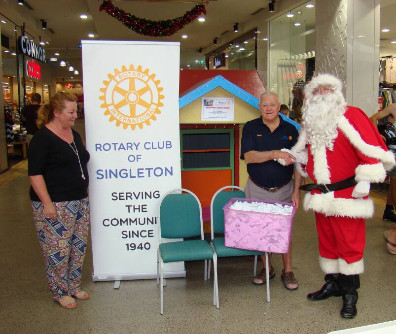 Anita White President of the Rotary Club of Singleton, Geoff Williams and Santa.