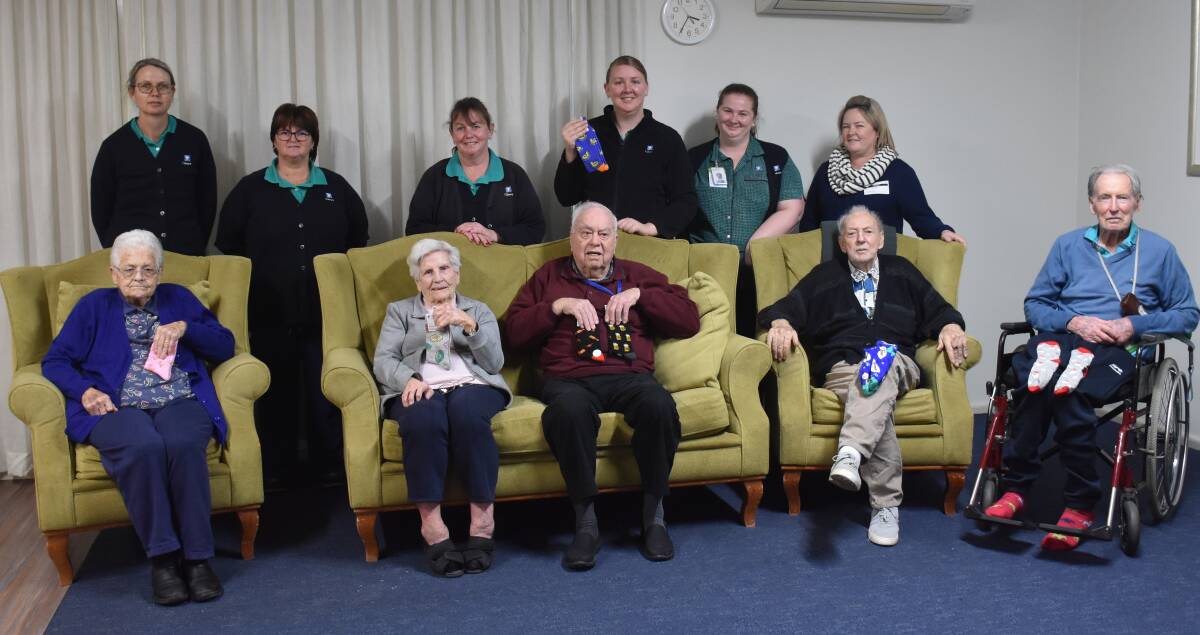 SILLY SOCKS: Staff and residents from Cooinda are encouraging all to buy some socks to help fund their next outdoor project. Back: Julie Bailey, Kylie Atfield, Lee Pearce, Taylor Gallagher, Emily Moore and Jodie Mackaway. Front: Shirley Burgmann, Elva Bailey, Ken Bailey, John McGinley and Geoff Marshall.