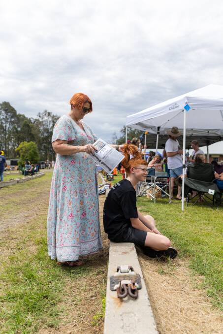 Jayce Bowers' mum, Sam, fans his nape as the humidity rises after morning showers at Mulletfest 2023. Picture by Simon McCarthy