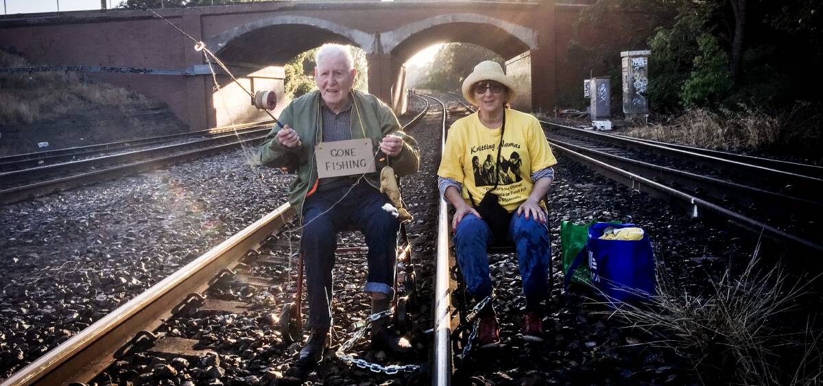 Protest: Kokoda veteran Bill Ryan, 96, and Susie Gold chained to the rail line as part of a series of protests against climate change. They were two of 26 people arrested and charged over the protests. 