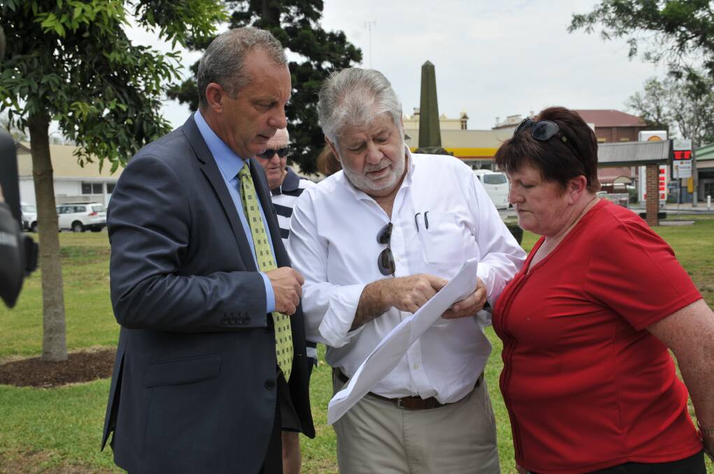 GATHERING: December 2016 Michael Johnsen, Bob Keown and Ruth Rogers look at the map of the preferred option for the future New England Highway bypass of Singleton.