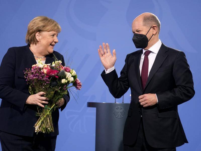 New elected German Chancellor Olaf Scholz (right) gave flowers to his predecessor Angela Merkel.