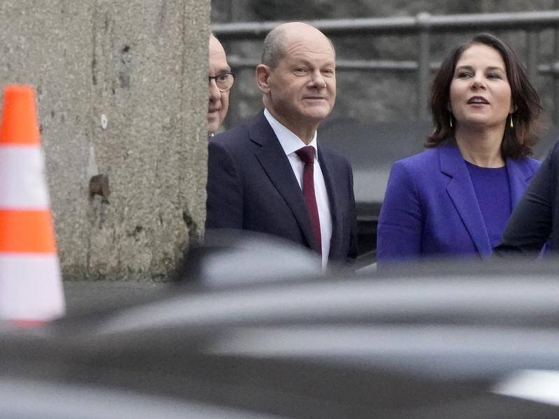 Olaf Scholz (centre) says he has reached a deal to form a new German coalition government.