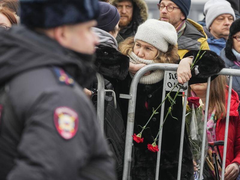 Police stand guard as people gather near the church hosting Alexei Navalny's funeral service. (AP PHOTO)