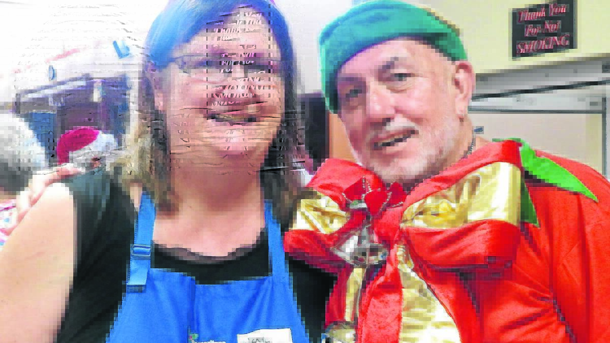 FULL OF CHEER: Samaritans Christmas Lunch organiser Wendy Love and Gary “The Elf” Holland at Singleton Senior Citizen’s Centre on Christmas Day.