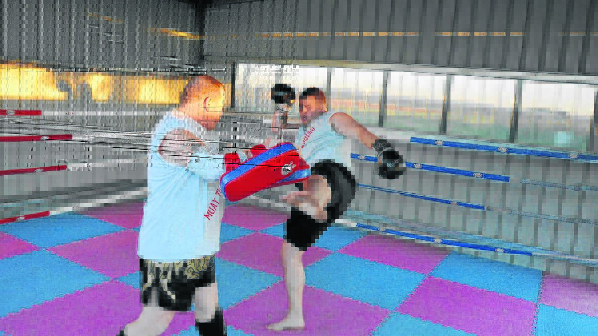 SPARRING MATCH:  Muay Thai Coach David Long(left) puts Brad Young through his paces this week in preparation for Brad’s fight on Saturday in Gosford. 