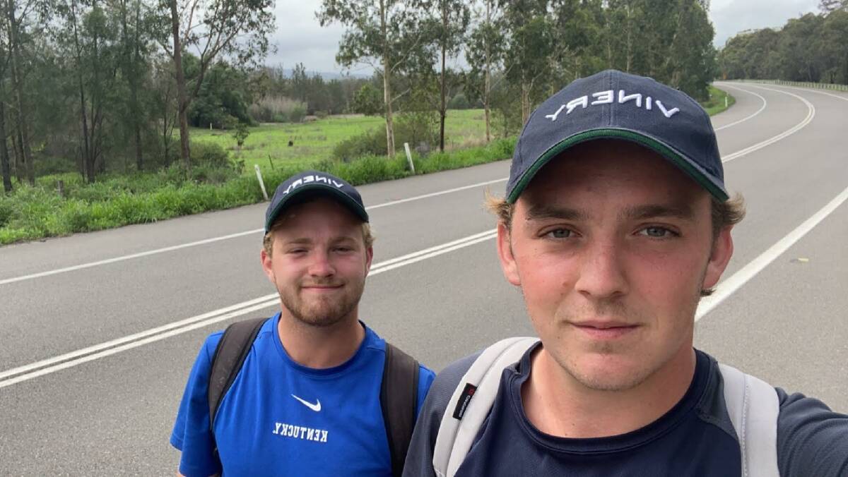 EARLIER IN THE DAY: Ed Goff and Harrison Badger pictured 18km north of Singleton at 9am on the New England Highway during their Scone to Sydney charity walk.