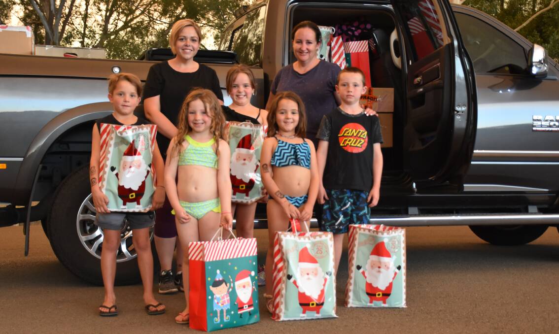 SEASON OF GIVING: Good friends Emma Kidd and Mel Shore pictured with their young helpers Hendrix Kidd, Maycie Shore, Adelaide Kidd, Hallie Kidd and Sullivan Shore on the eve of Mel's drive to the Cobar region. There she would share three car loads of Christmas packages donated by the Singleton community.