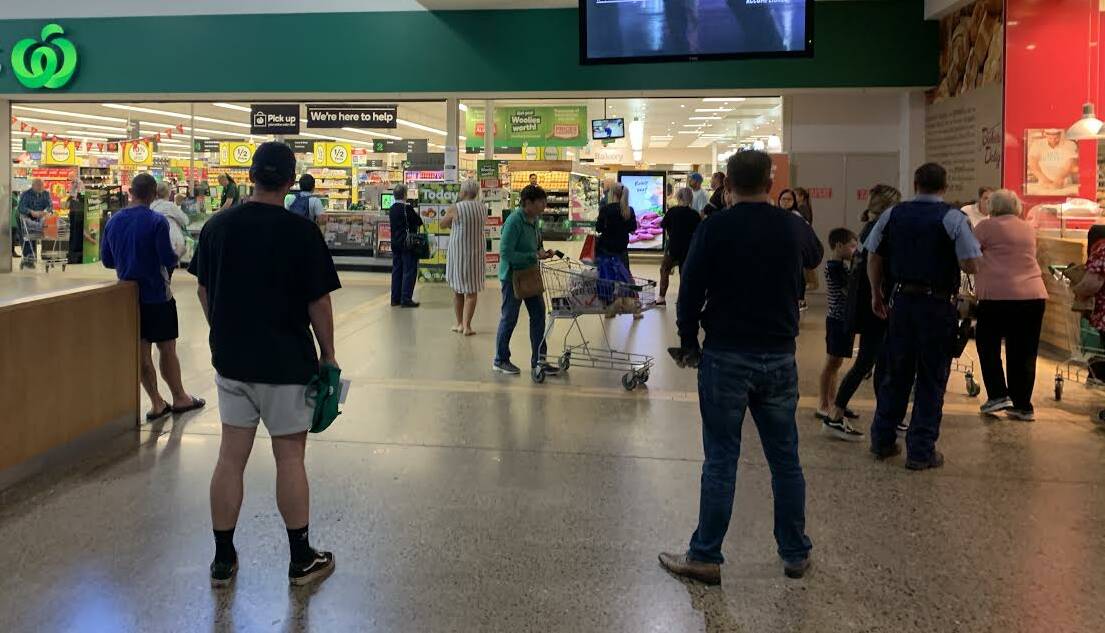 WAITING: Customers not permitted to enter Singleton's Woolworths during elderly hour countdown until 8am to access the supermarket.