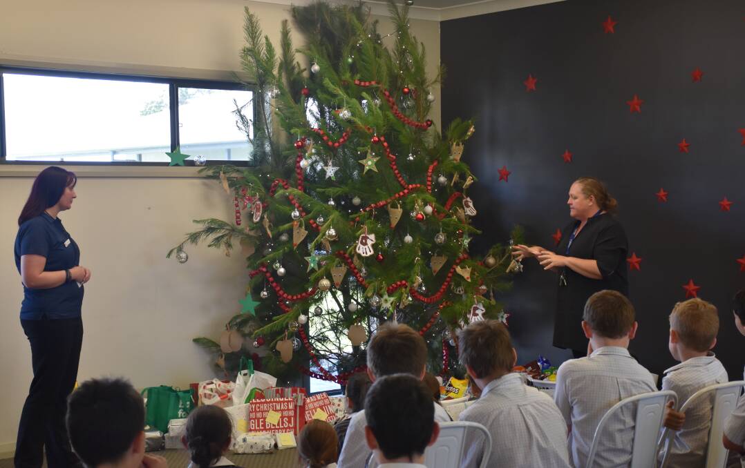OH CHRISTMAS TREE: Emma Parrey (Salvation Army Welfare Youth Minister) listens to Australian Christian College Singleton teacher Katie Kelly reflect on the initiative.