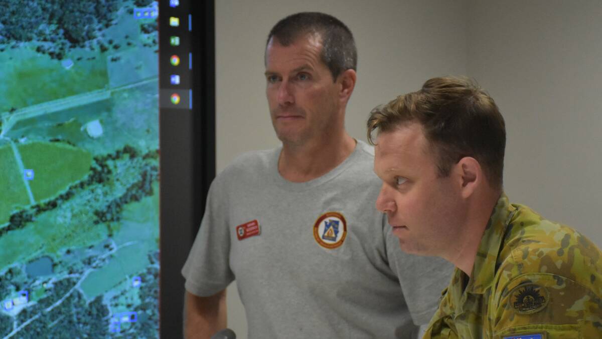 WORKING TOGETHER: Fire management officer Nathan Goodrich (USDA Forrest Service) pictured alongside a Corporal from the Australian Army Reserve at the Hunter Valley RFS control room this week.