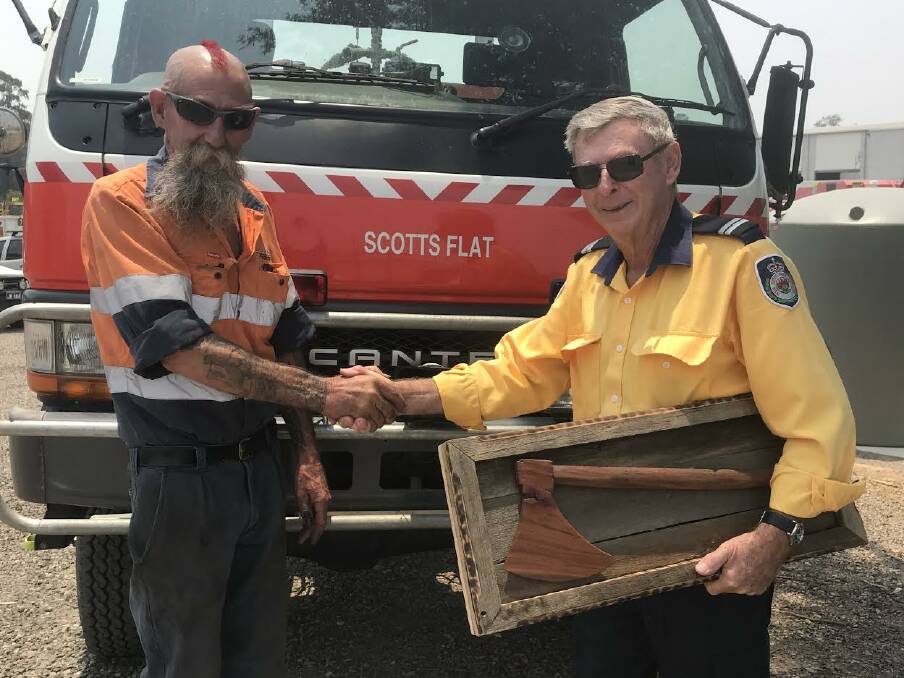 PRESENTATION: Boilermaker Neil 'Jumbo' Collins presents Scotts Flat RFS captain George Dick with a wodden axe.