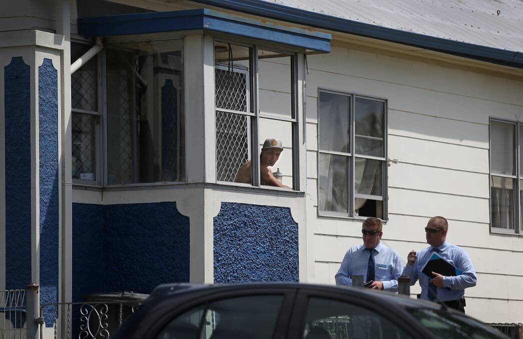PARTY HOUSE: Detectives speak to a man at the Ida Street home on Wednesday morning after hundreds spilled out of a party on Friday night. Picture: Marina Neil 